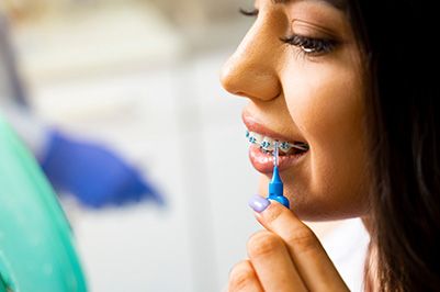 Closeup of patient using interproximal toothbrush