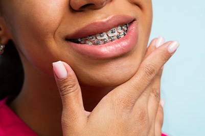 Close up of a young person smiling with metal braces