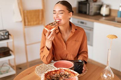 Woman smiling while enjoying home-made pizza