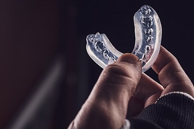 Closeup of patient holding clear mouthguard