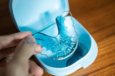 Patient placing blue retainer in case