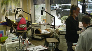 Team members working with patients in exam room