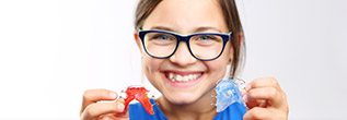 Young girl holding retainers