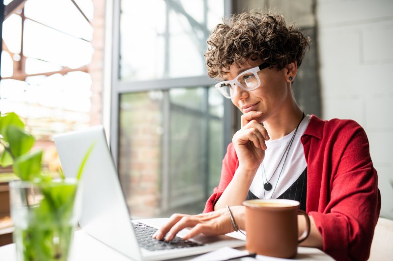 Woman researching orthodontists on laptop in apartment