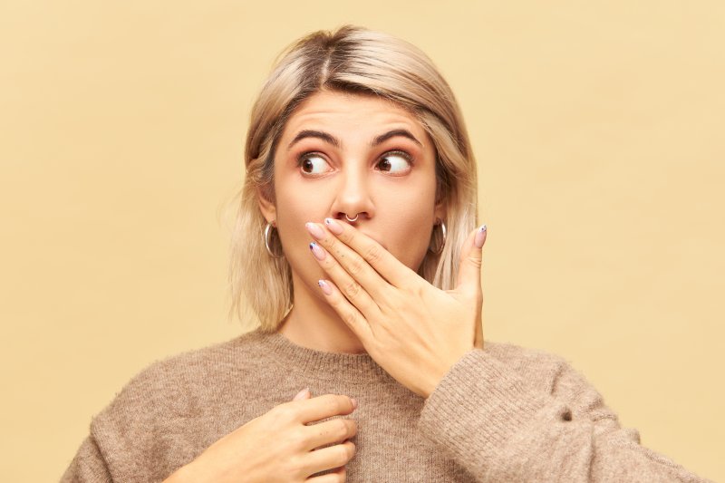 A patient covering her broken braces